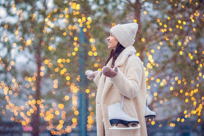 Full length of woman standing by tree in winter