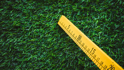 Close-up of measuring tape on grass field