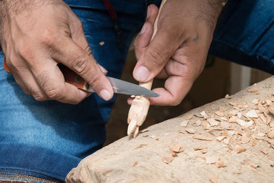 Cropped hands of carpenter working in carpentry workshop