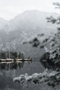 Scenic view of lake by snowcapped mountains against sky