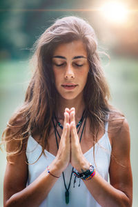 Woman doing yoga while sitting on pier at lake