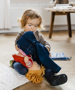 Cute girl sitting on floor at home