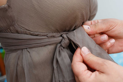 Cropped hands of person tying bow