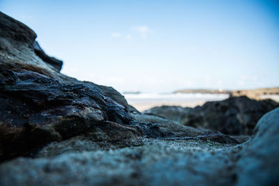 Surface level of rocky shore against clear sky