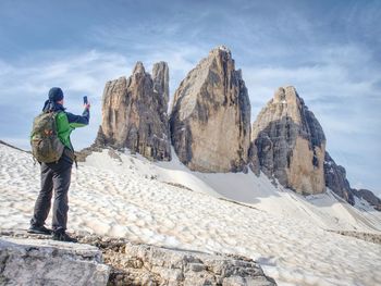 Hiker on trail around summit of mountain peaks. success, freedom and happiness. active sport concept