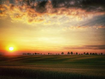 Scenic view of field against cloudy sky