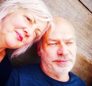 Close-up of couple looking away against wooden wall