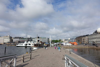 Boats moored in river with buildings in background