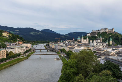 River amidst buildings in city against sky