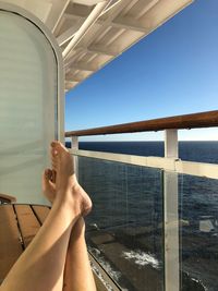 Low section of woman in sea against sky