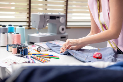 Portrait of a young, attractive woman on a stylish fashion designer's table,.