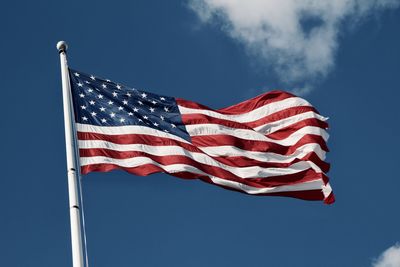 Low angle view of flag against blue sky