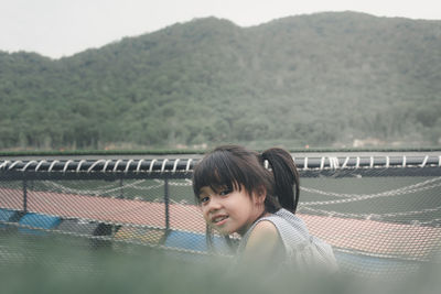 Portrait of cute girl sitting on netting