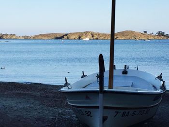 Boat moored at beach against sky