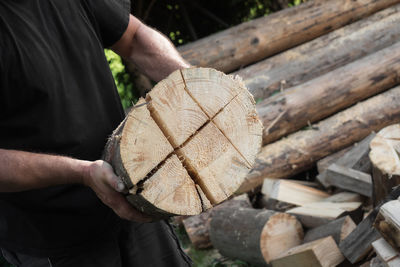 Close-up of man hand holding logs