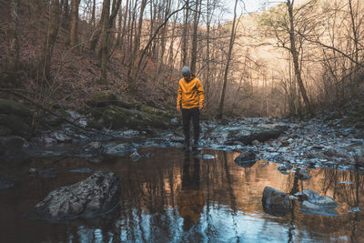 Rear view of man standing in puddle