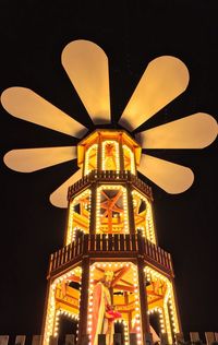 Low angle view of illuminated building against sky at night