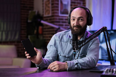 Young man using mobile phone while sitting on table