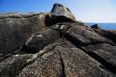 Rock formation on beach against sky