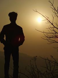 Silhouette man standing against sky during sunset