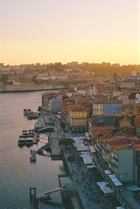 High angle view of townscape by sea against sky during sunset