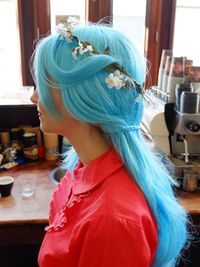 Young woman with dyed hair in kitchen