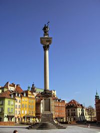 Statue in city against clear sky