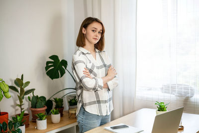 Young woman working on laptop at home. cozy home office workplace, remote work, e-learning concept. 