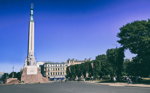 Street amidst buildings against blue sky