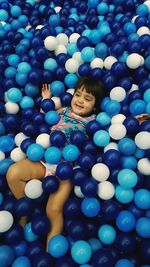 Smiling girl lying on blue balls