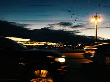 Low angle view of power lines at sunset