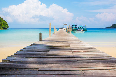 Wooden pier over sea against sky