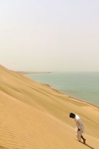 High angle view of man walking in desert against sea