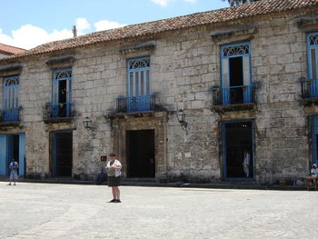 Woman standing on window of building