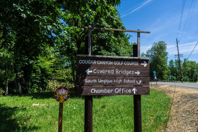 Information sign on pole against sky