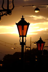 Silhouette street light against orange sky