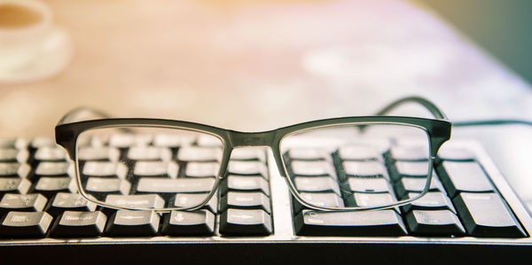 Close-up of computer keyboard and eyeglasses