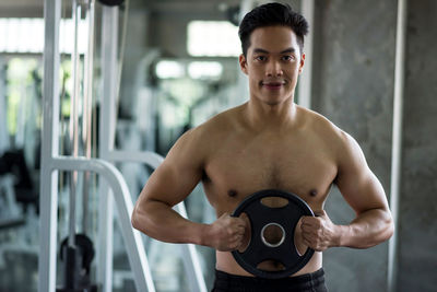 Shirtless muscular man exercising in gym