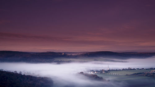 Scenic view of foggy landscape against sky at night
