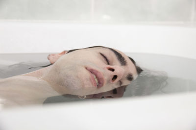 Portrait of man lying down in bathroom