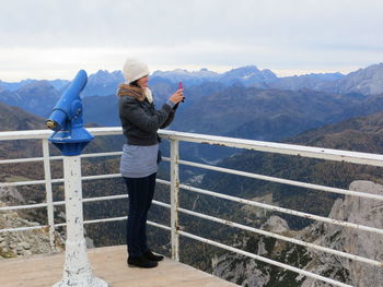 Full length of woman photographing mountains from observation point