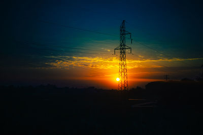 Low angle view of silhouette electricity pylon against sky during sunset