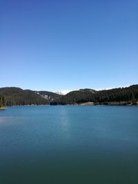 Scenic view of lake against clear blue sky