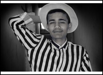 Portrait of smiling boy standing against hat