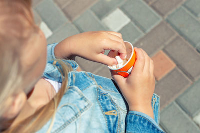 High angle view of girl with candy standing on footpath