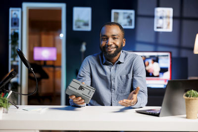 Portrait of young man using mobile phone in office