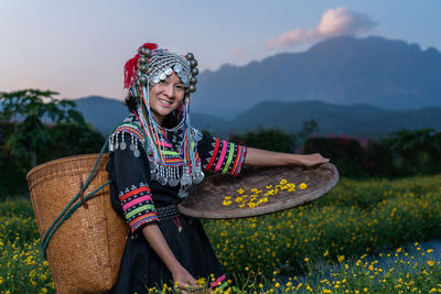 Portrait of smiling woman holding umbrella on field