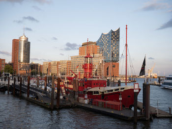 Commercial dock by sea against sky in city