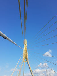 Low angle view of suspension bridge against clear blue sky