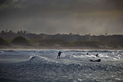 People on sea shore against sky